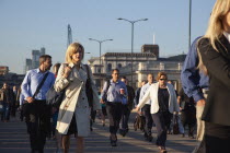 England, London, Early morning commuters crossing London Bridge towards the City Financial district.