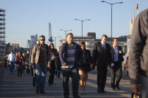 England, London, Early morning commuters crossing London Bridge towards the City Financial district.