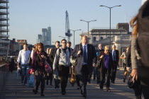 England, London, Early morning commuters crossing London Bridge towards the City Financial district.