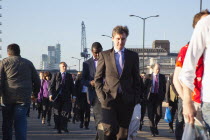 England, London, Early morning commuters crossing London Bridge towards the City Financial district.