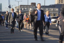 England, London, Early morning commuters crossing London Bridge towards the City Financial district.