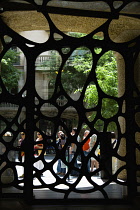 Spain, Catalonia, Barcelona, Gate from the street to the central courtyard of Casa Mila apartment building known as La Pedrera or Stone Quarry designed by Antoni Gaudi in the Eixample district.