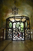 Spain, Catalonia, Barcelona, Gate from the street to the central courtyard of Casa Mila apartment building known as La Pedrera or Stone Quarry designed by Antoni Gaudi in the Eixample district.