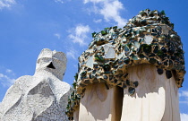 Spain, Catalonia, Barcelona, Chimneys and vents on the roof of Casa Mila apartment building known as La Pedrera or Stone Quarry designed by Antoni Gaudi in the Eixample district.