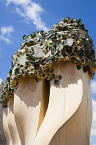 Spain, Catalonia, Barcelona, Chimneys and vents on the roof of Casa Mila apartment building known as La Pedrera or Stone Quarry designed by Antoni Gaudi in the Eixample district.