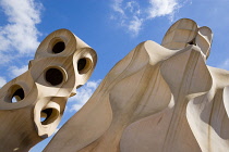 Spain, Catalonia, Barcelona, Chimneys and vents on the roof of Casa Mila apartment building known as La Pedrera or Stone Quarry designed by Antoni Gaudi in the Eixample district.