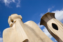 Spain, Catalonia, Barcelona, Chimneys and vents on the roof of Casa Mila apartment building known as La Pedrera or Stone Quarry designed by Antoni Gaudi in the Eixample district.