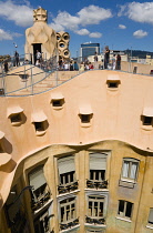 Spain, catalonia, Barcelona, Tourist visitors on the roof of Casa Mila apartment building known as La Pedrera or Stone Quarry designed by Antoni Gaudi in the Eixample district.