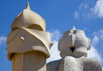 Spain, Catalonia, Barcelona, Chimneys and vents on the roof of Casa Mila apartment building known as La Pedrera or Stone Quarry designed by Antoni Gaudi in the Eixample district.