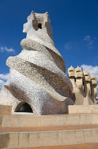 Spain, Catalonia, Barcelona, Chimneys and vents on the roof of Casa Mila apartment building known as La Pedrera or Stone Quarry designed by Antoni Gaudi in the Eixample district.