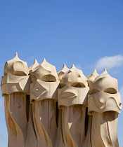 Spain, Catalonia, Barcelona, Chimneys and vents on the roof of Casa Mila apartment building known as La Pedrera or Stone Quarry designed by Antoni Gaudi in the Eixample district.