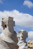 Spain, Catalonia, Barcelona, Chimneys and vents on the roof of Casa Mila apartment building known as La Pedrera or Stone Quarry designed by Antoni Gaudi in the Eixample district.