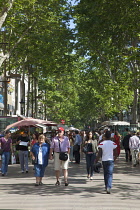 Spain, Catalonia, Barcelona, Tourist walking along the tree lined avenue of La Rambla.