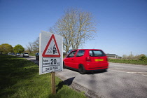 Transport, Road, Cars, resurfaced road with sign warning of reduced speed limit and loose chippings.