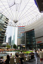 Germany, Berlin, Mitte, Potsdamer Platz, The Sony Centre designed by architect Helmut Jahn with the canopy over the central Forum of restaurants, offices, cinemas, shops and apartments with people eat...