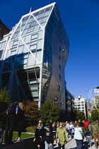 USA, New York, Manhattan, High Line linear park between buildings on a disused elevated railroad spur with people on a path beside the 23rd Street Lawn.