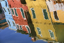 Italy, Veneto, Burano Island, Colourful housing reflected in canal.