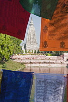 India, Bihar, Bodhgaya, Mahabodhi Temple framed by colourful Buddhist prayer flags.