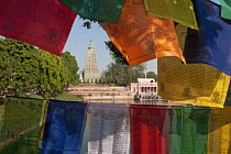 India, Bihar, Bodhgaya, Mahabodhi Temple framed by colourful Buddhist prayer flags.