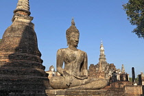 Thailand, Sukothai, Large, seated Buddha among the stupas and towers of Wat Mahathat Royal Temple.