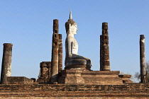 Thailand, Sukothai, Seated, white Buddha framed by brick pillars, Wat Mahathat Royal Temple.