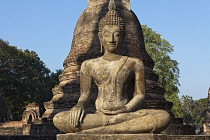 Thailand, Sukothai, Seated Buddha with a large, brick stupa in the background, Wat Mahathat Royal Temple.