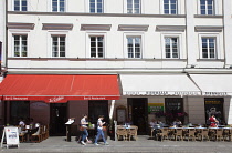 Poland, Warsaw, Nowy Swiat, Exterior of restaurants with tables outside.