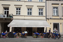 Poland, Warsaw, Nowy Swiat, Exterior of restaurants with tables outside.