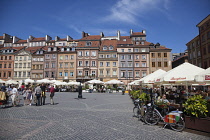 Poland, Warsaw, Old Town Square, rynek Starego Miasta, Tourists sat at outdoor restaurant seating area.