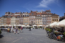 Poland, Warsaw, Old Town Square, rynek Starego Miasta, Tourists sat at outdoor restaurant seating area.