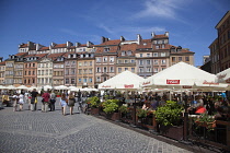 Poland, Warsaw, Old Town Square, rynek Starego Miasta, Tourists sat at outdoor restaurant seating area.