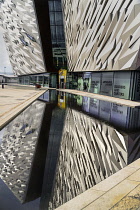 Ireland, Belfast, Titanic Quarter, Titanic Belfast Visitor Experience, Section of the building reflected in pool.