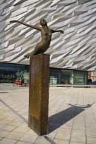 Ireland, Belfast, Titanic Quarter, Titanic Belfast Visitor Experience, 'Titanica' sculpture by Rowan Gillespie with section of the building in the background.