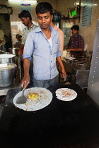 India, Telengana, Hyderabad, Man cooking a masala dosa.