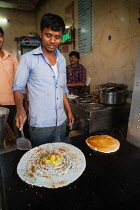 India, Telengana, Hyderabad, Man cooking a masala dosa.