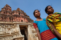 India, Karnataka, Hampi, Portrait of two girls in front of the gopuram at the entrance to the Vitthala Temple in Hampi.