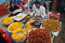 India, Karnataka, Bijapur, Sweet food and snack vendor in Bijapur market.