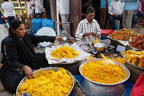 India, Karnataka, Bijapur, Sweet food and snack vendor in Bijapur market.