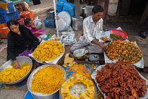 India, Karnataka, Bijapur, Sweet food and snack vendor in Bijapur market.