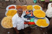 India, Karnataka, Bijapur, Sweet food and snack vendor in Bijapur market.