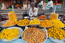 India, Karnataka, Bijapur, Sweet food and snack vendor in Bijapur market.