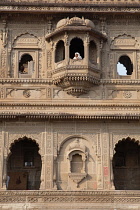 India, Madhya Pradesh, Maheshwar, A woman looks out from a balcony window at Ahilya Fort in Maheshwar.