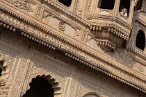 India, Madhya Pradesh, Maheshwar, A woman looks out from a balcony window at Ahilya Fort in Maheshwar.