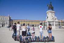 Portugal, Estremadura, Lisbon, Baixa, Praca do Comercio, Segway guided tour of the square with equestrian statue of King Jose and Rua Augusta triumphal arch.