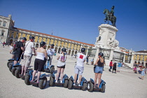 Portugal, Estremadura, Lisbon, Baixa, Praca do Comercio, Segway guided tour of the square with equestrian statue of King Jose and Rua Augusta triumphal arch.