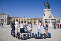 Portugal, Estremadura, Lisbon, Baixa, Praca do Comercio, Segway guided tour of the square with equestrian statue of King Jose and Rua Augusta triumphal arch.