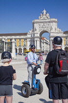 Portugal, Estremadura, Lisbon, Baixa, Praca do Comercio, Segway guided tour of the square with equestrian statue of King Jose and Rua Augusta triumphal arch.