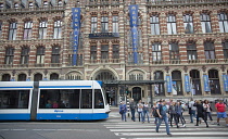 Holland, North, Amsterdam, Exterior of Magna Plaza store with tram and pedestrian crossing.