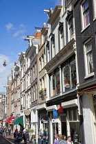 Holland, North, Amsterdam, Busy street full of tourists shopping.