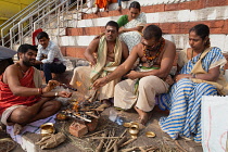 India, Uttar Pradesh, Varanasi, A pundit performs a puja for a bereaved family at Kedar Ghat.